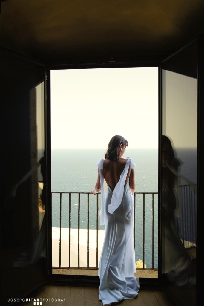 Bride in a wedding dress gazing at the sea on the Costa Brava — the perfect Mediterranean setting for a dream wedding in Spain