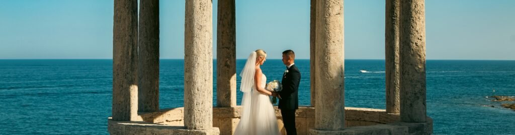 Bride and groom gazing at each other during their wedding day by the Mediterranean Sea in Barcelona