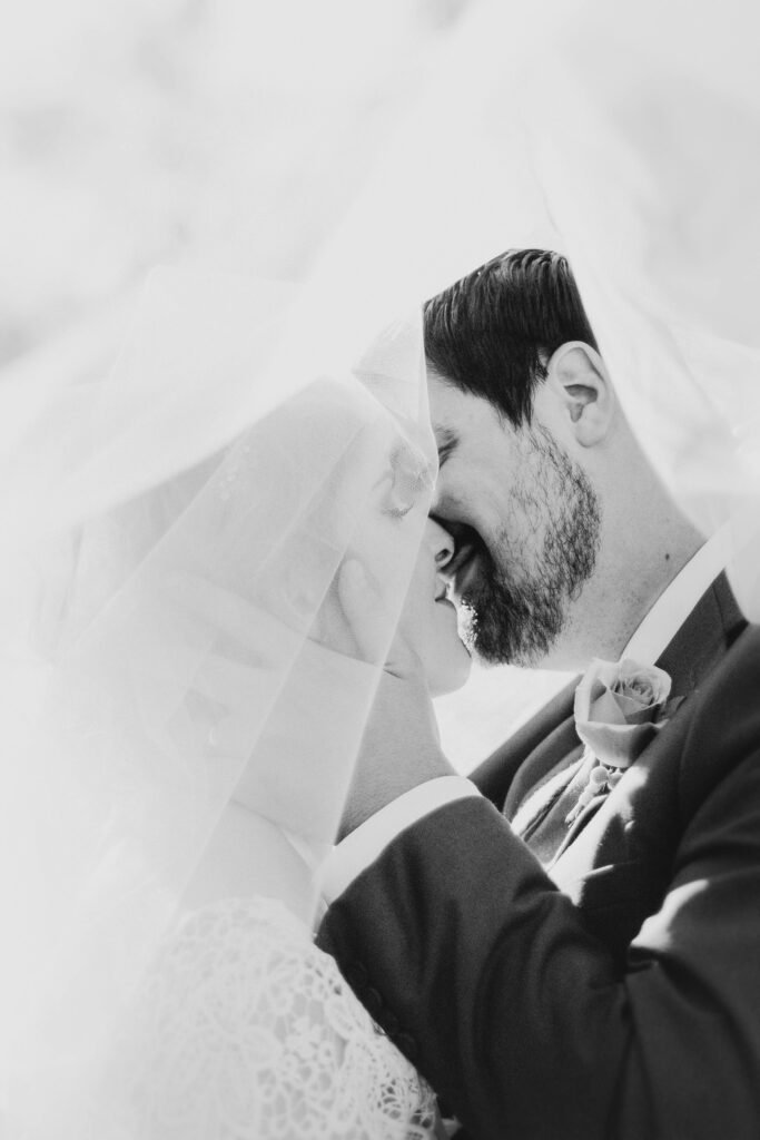 Romantic black and white photo of a couple kissing during their destination wedding in Barcelona — timeless elegance for Swiss couples in love.